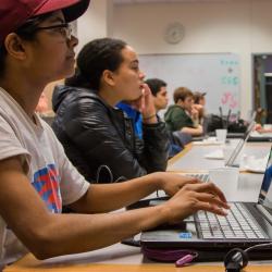 Students on laptops in a classroom.