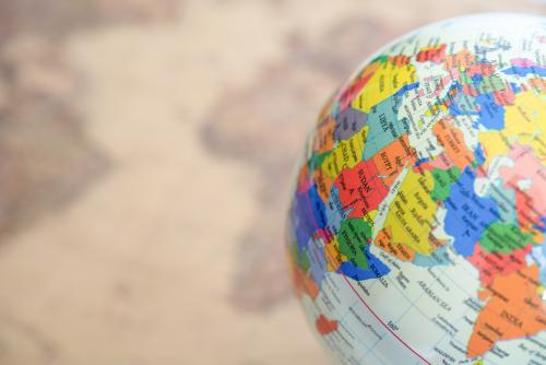 A colorful globe in the foreground shown over a blurred map in the background.